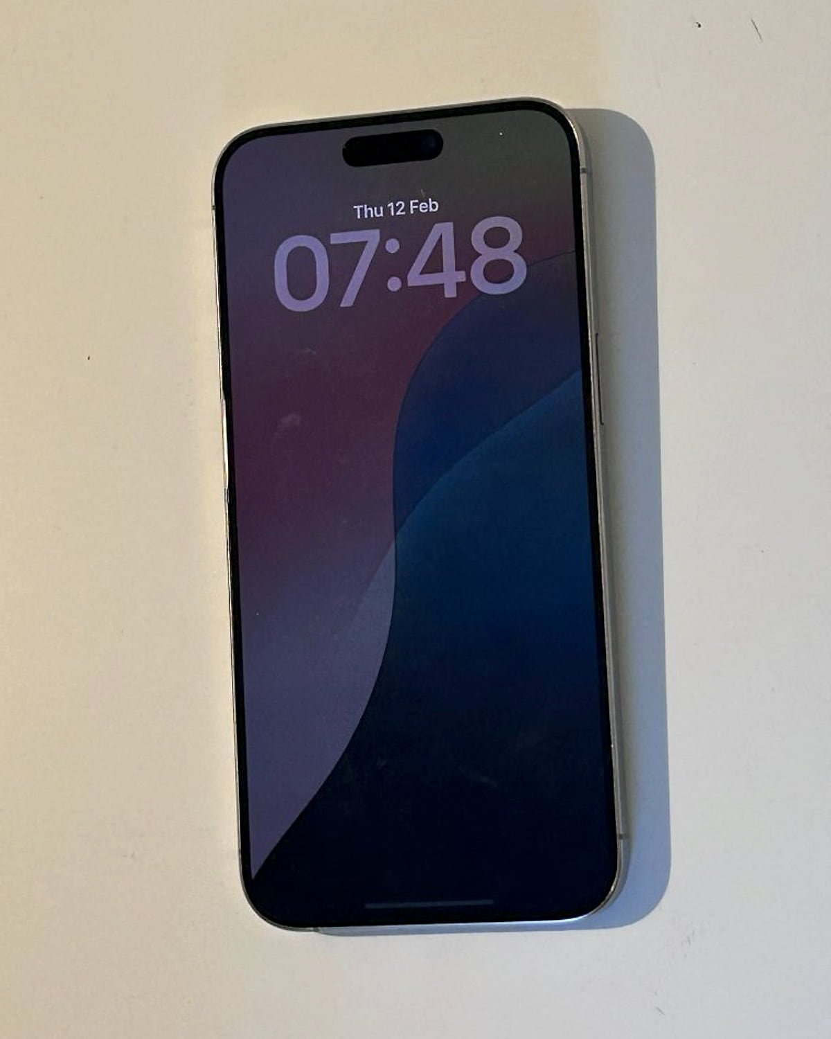 An iPhone with the lock screen on, lying on a desk