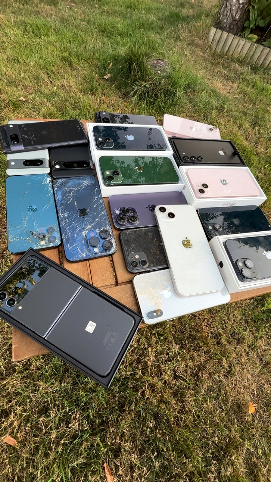 Phones on a table, two with shattered back glass