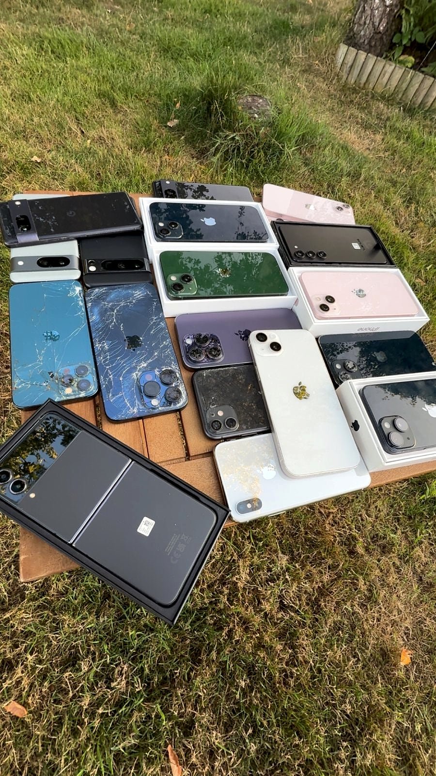 Phones on a table, two with shattered back glass